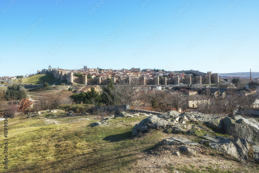 Historic city of Avila with it's famous medieval town walls surround at the sunny winter day, Spain