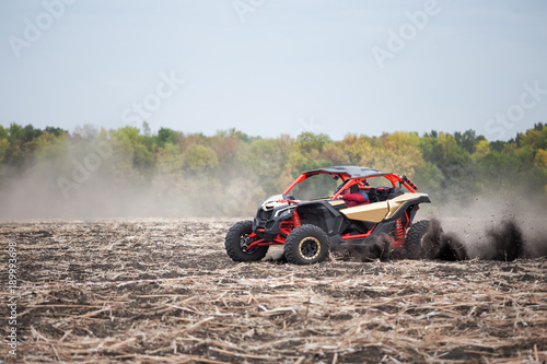 Quad bike with driver in plowed field