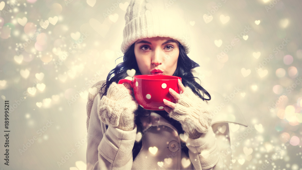 Happy young woman in winter clothes drinking coffee Happy young woman in winter clothes drinking coffee