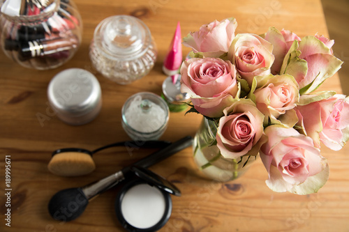 Make Up und Schminke auf Tisch mit Rosa Rosenstrauß photo