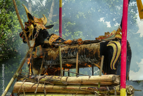 Balinese Cremation Ceremony. A Balinese cremation is held to release the soul of a dead person so that it can enter the upper realm where it can wait for it to be reborn. The bull is called a lembu. photo