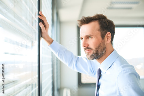 Foto businessman looking through the window at office