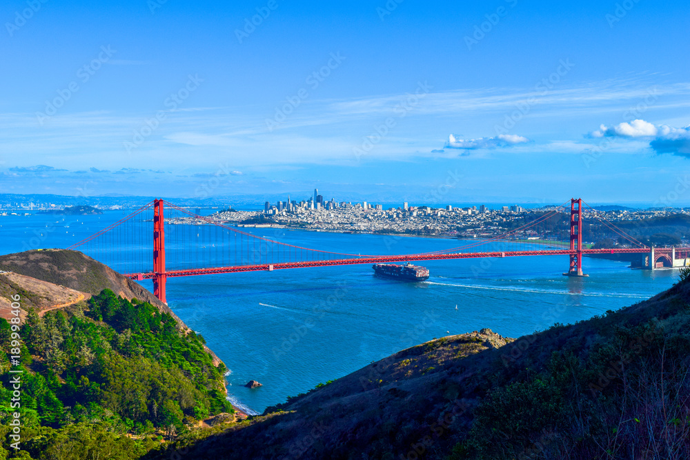 Großes Transportschiff fährt unter der Golden Gate Bridge hindurch, San Francisco Skyline im Hintergrund, USA, Kalifornien, Ausblick von Marin Headlands
