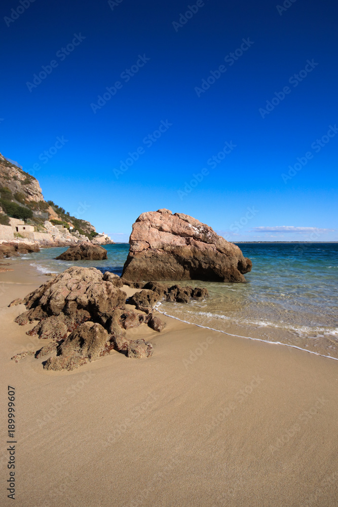 Beach with turquoise sea water with amazing rocks. Setubal in Portugal