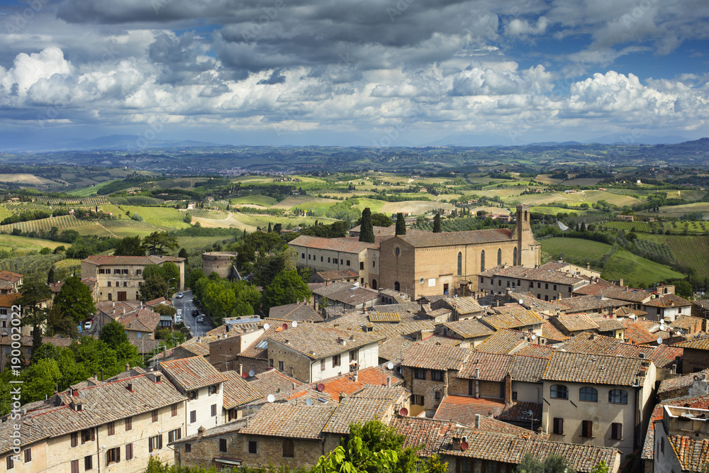 aerial view to old Tuscany city and city roofs under cloudy sky in spring day in Italy