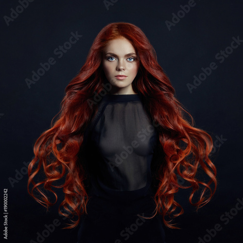 Canvas Print Portrait of redhead sexy woman with long hair on black background