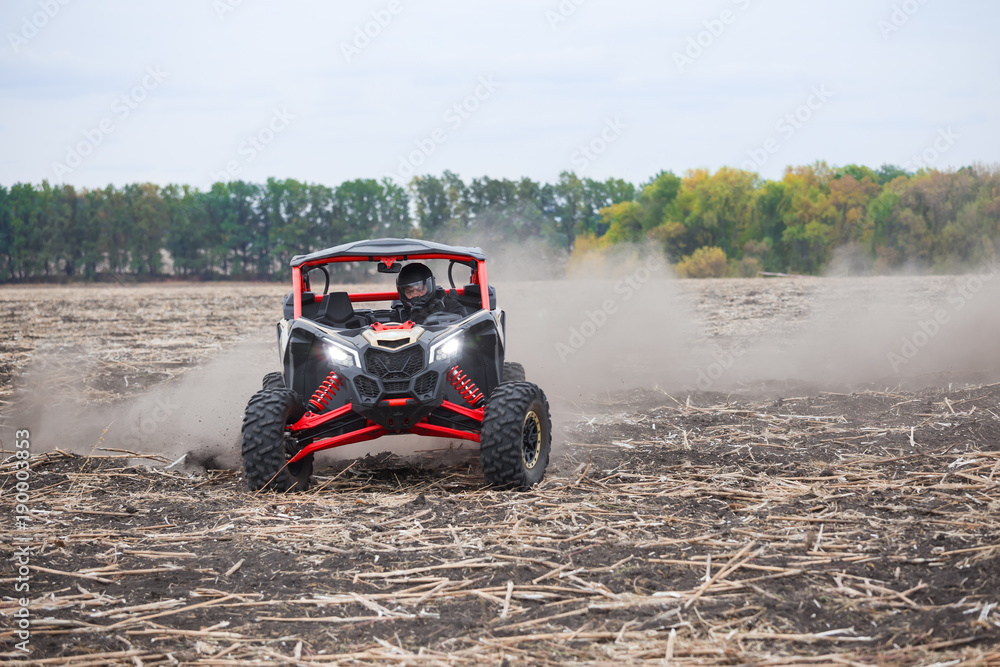 Driver in helmet on quad bike on a plowed field Driver in helmet on quad bike on a plowed field