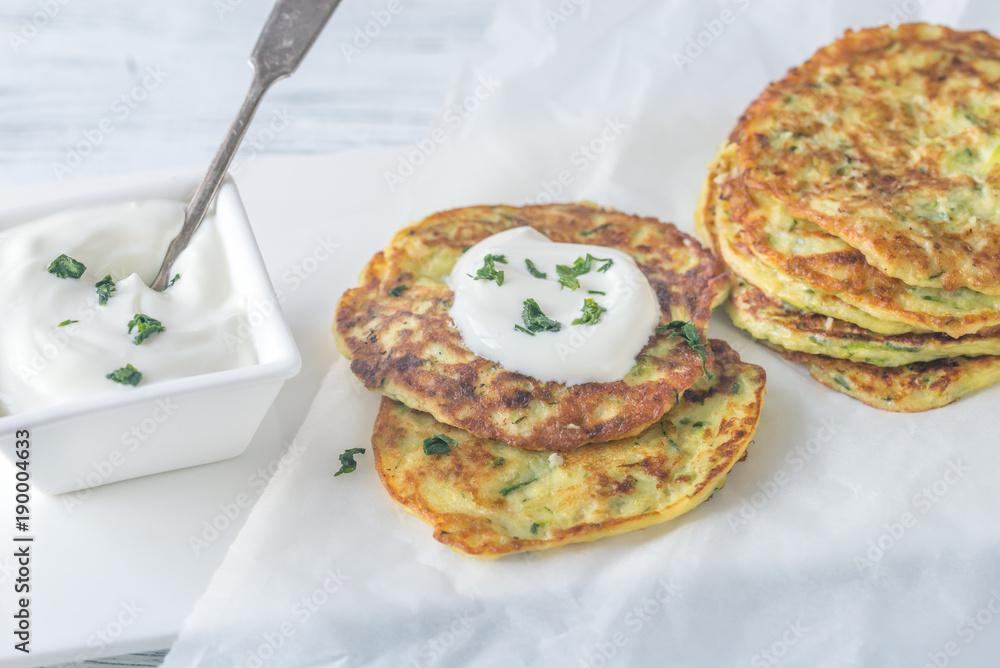 Portion of zucchini fritters with greek yogurt Portion of zucchini fritters with greek yogurt