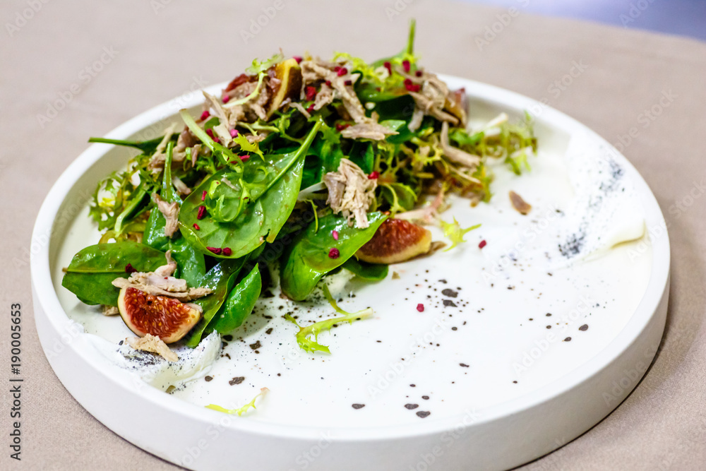 Salad with meat and figs lies on the plate Salad with meat and figs lies on the plate