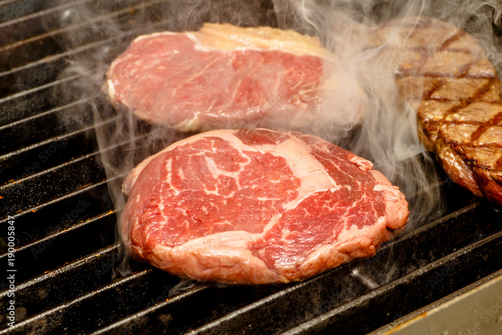 The chef cooks steaks on the grill. The chef cooks steaks on the grill.