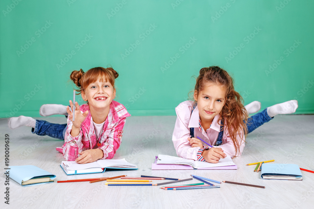 Two fun little children do homework. The concept of childhood, learning, friendship, family, school, lifestyle. Two fun little children do homework. The concept of childhood, learning, friendship, family, school, lifestyle.