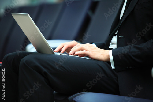 Young adult using laptop in airport lounge