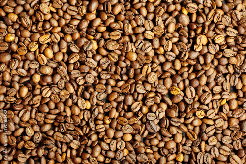 Coffee beans on a black textured background.