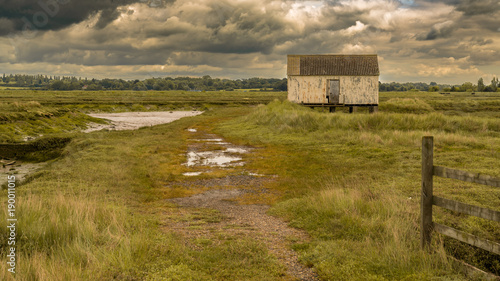 Fotografie, Obraz House on stilts in the marshland near the River Crouch, Wallasea Island, Essex,
