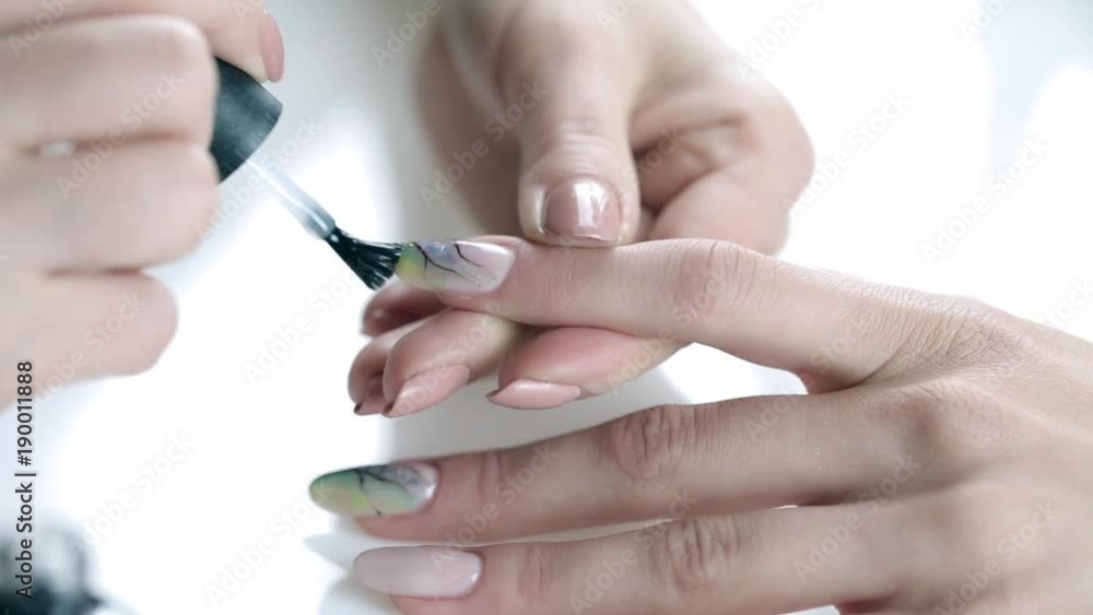 Women paints nails.Manicure Nail Art close up. Beautiful Nail Art Manicure. Nail designs with decoration.Manicure nail paint. Women paints nails.Manicure Nail Art close up. Beautiful Nail Art Manicure. Nail designs with decoration.Manicure nail paint.