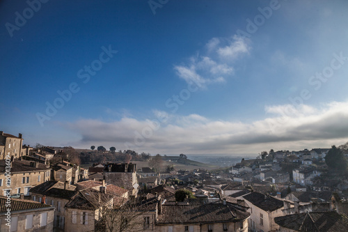 Panorama of the medieval city of Saint Emilion, France with the wineyards in background, during a sunny afternoon. Saint Emilion, famous for its Bordeaux wines, is one of the oldest cities of the area