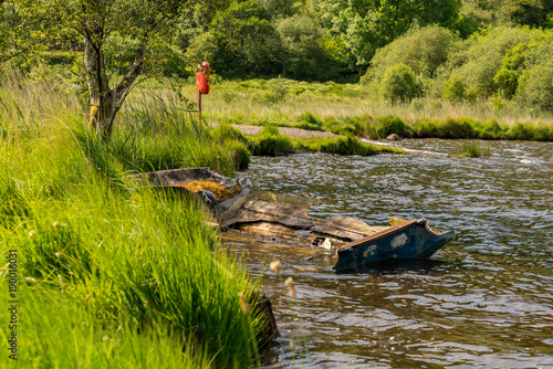 A damaged boat on the shore of Llyn Geirionydd, near Llanwrst, Conwy, Wales, UK photo