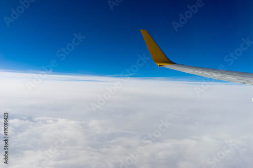 Clouds and wing, view from the window of airplane flying in the clouds