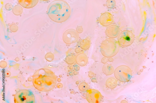 Abstract multicolored background on a liquid with oil, multicolored oil drops on a pink background, cosmic holographic pattern, minimalism, pop art texture for a designer, art