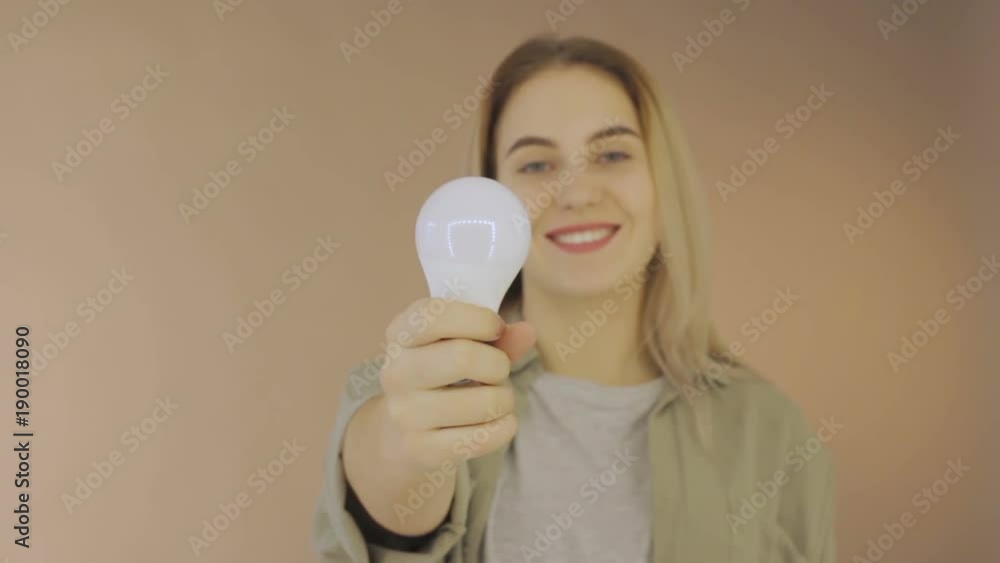 Young cute woman with electric bulb, studio Young cute woman with electric bulb, studio