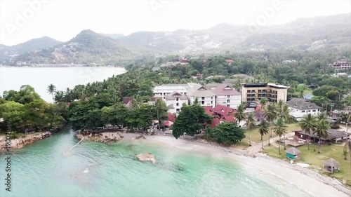 Aerial of Beautiful Fisherman Village and Pier, Top View. Video. Top view of a tropical village by the sea photo