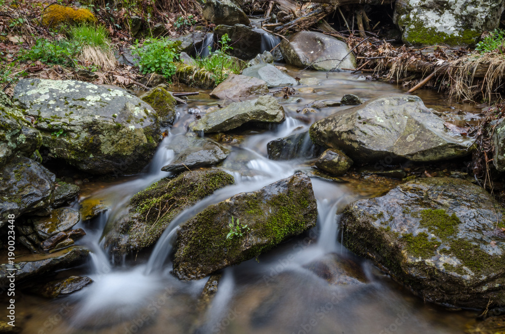 quiet serene stream flowing around large rocks quiet serene stream flowing around large rocks