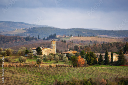 Tuscan landscape with cypress, trees and ancient buildings.