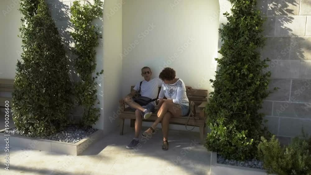 An older couple siting on the bench enjoying the sunset An older couple siting on the bench enjoying the sunset