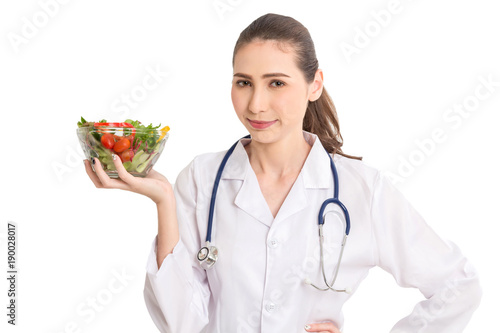 Woman doctor holding a plate with fresh vegetables salad isolated on white background