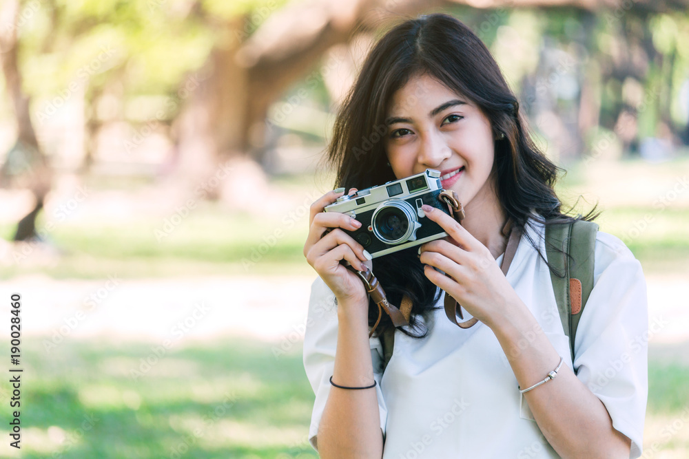 Asian woman taking picture with camera in park Asian woman taking picture with camera in park