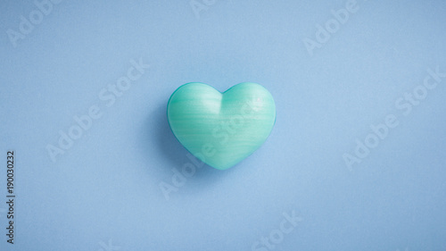 Turquoise heart shape over blue table. Romantic Valentine Day concept with copy space