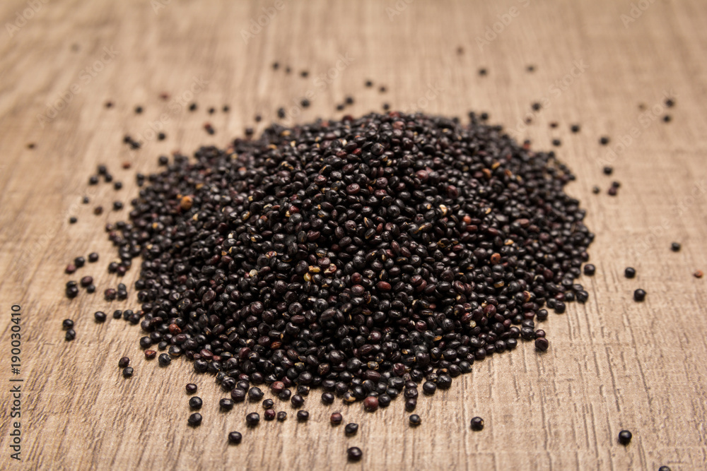 Black Quinoa seed. Pile of grains on the wooden table. Selective focus. Black Quinoa seed. Pile of grains on the wooden table. Selective focus.
