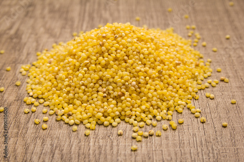 Proso Millet cereal grain. Pile of grains on the wooden table. Selective focus.