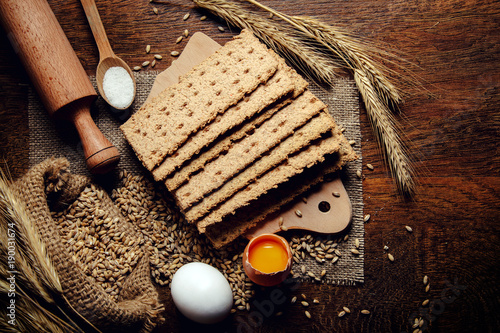 crispbread and ingredients, eggs, flour on rustic wooden table
