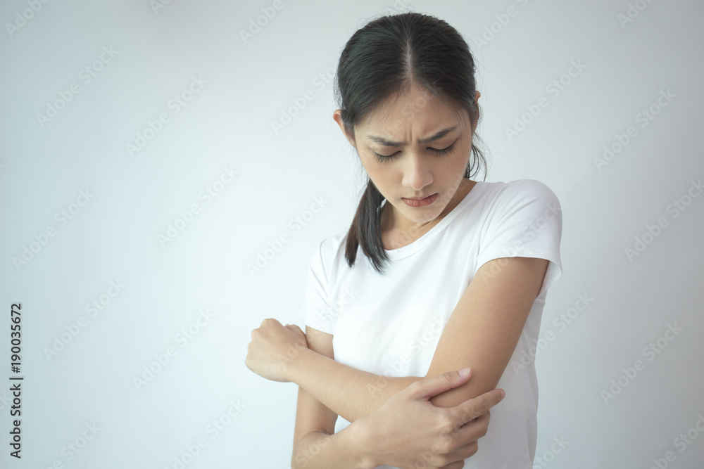 Woman touching her elbow with hands. Young asian woman feel pain in her elbow. isolated on withe background. Woman touching her elbow with hands. Young asian woman feel pain in her elbow. isolated on withe background.