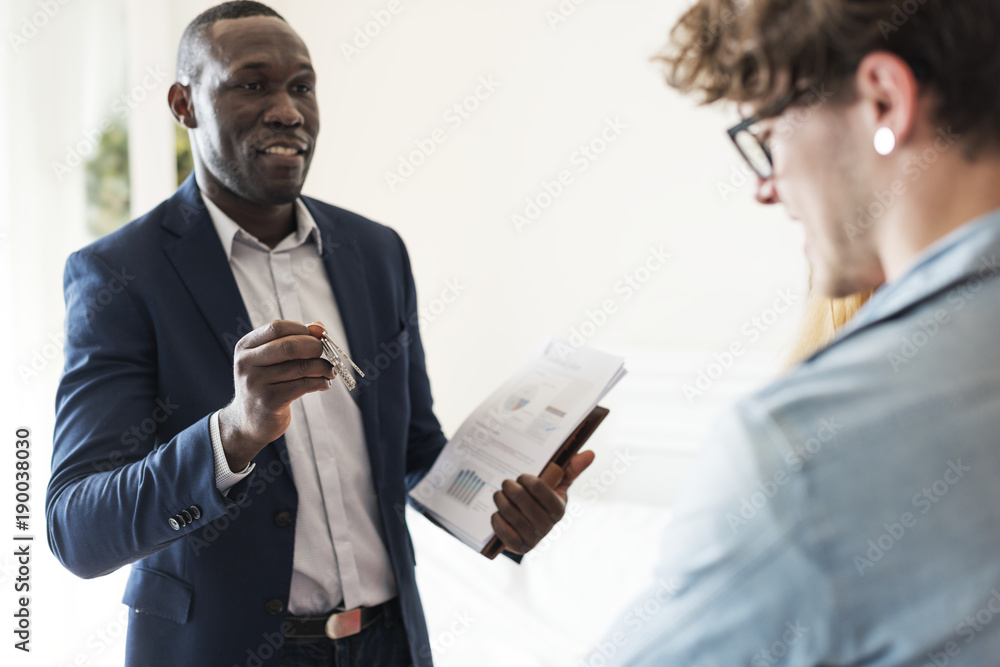 Real estate agent handing the house key to clients Real estate agent handing the house key to clients