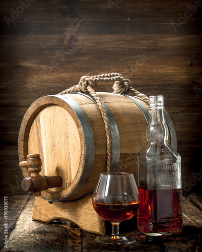 Cognac in a barrel with a glass.