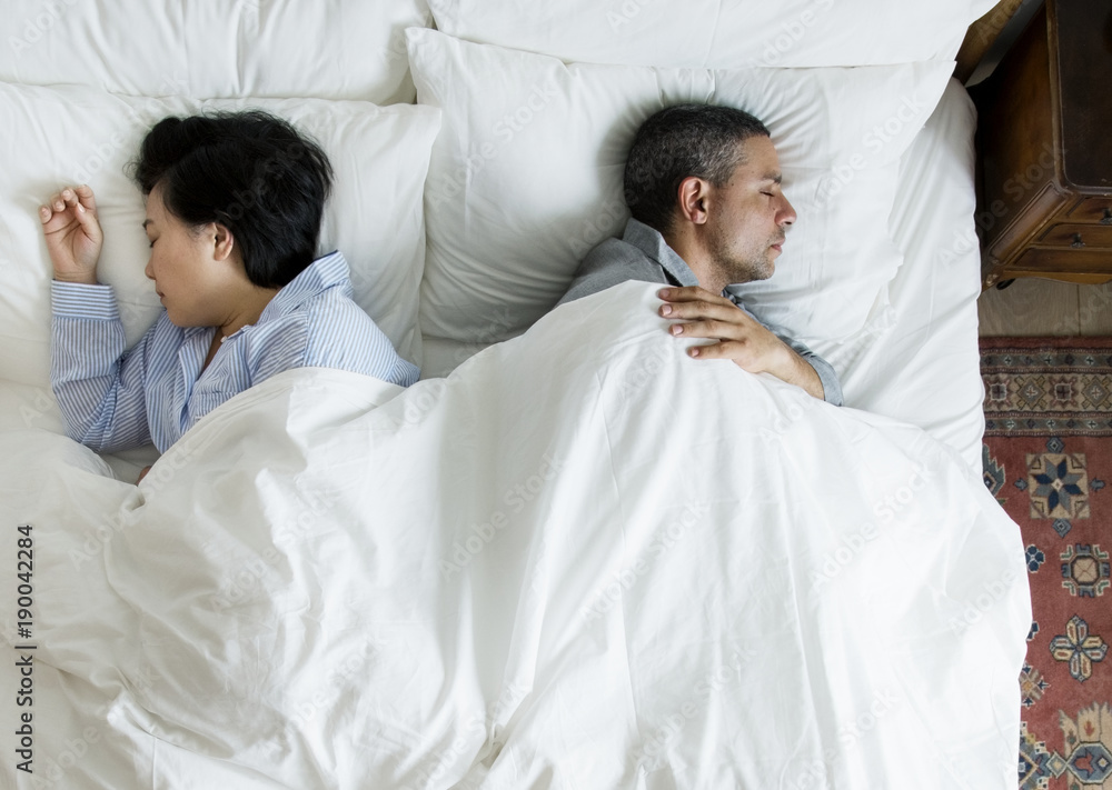 Interracial couple sleeping back to back on the bed Interracial couple sleeping back to back on the bed