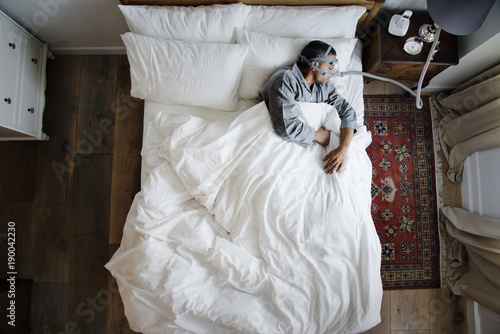 Man sleeping with an anti-snoring mask on photo