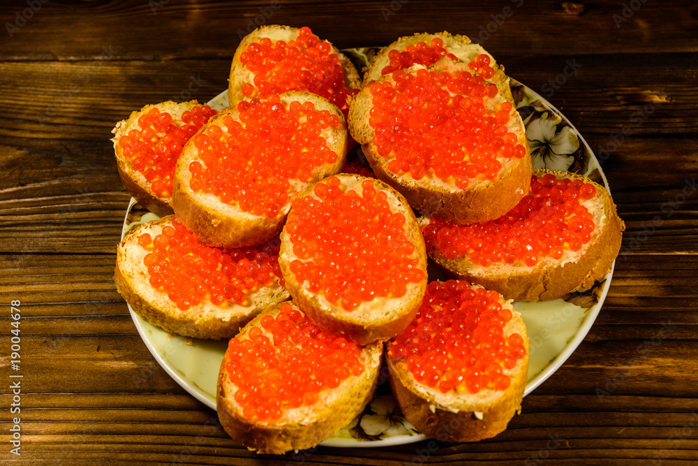 Sandwiches with red caviar on wooden table. Top view Sandwiches with red caviar on wooden table. Top view
