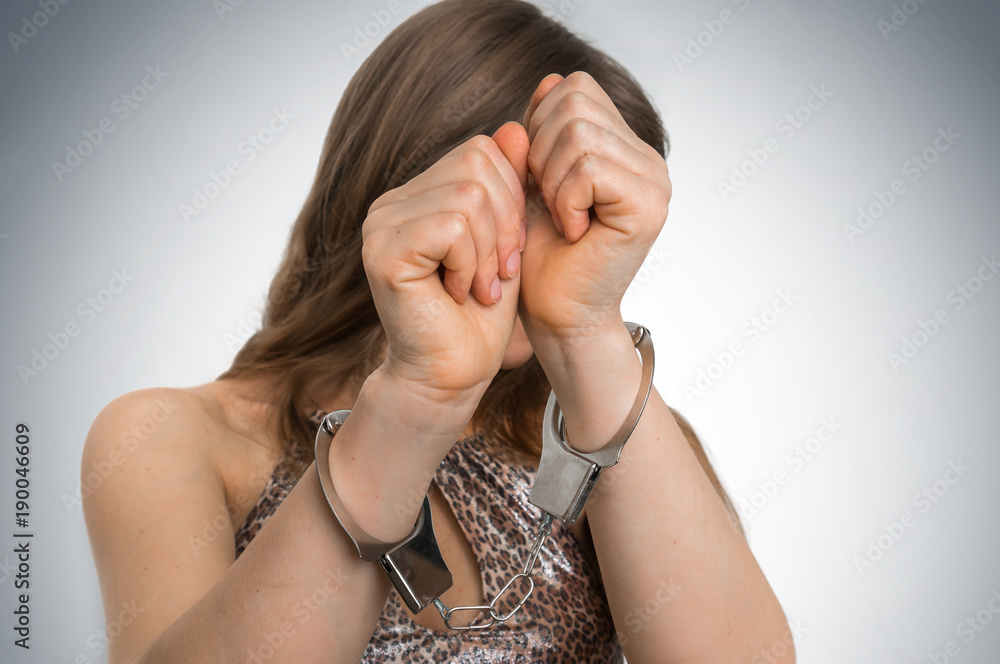 Arrested woman in handcuffs hidden her face Arrested woman in handcuffs hidden her face
