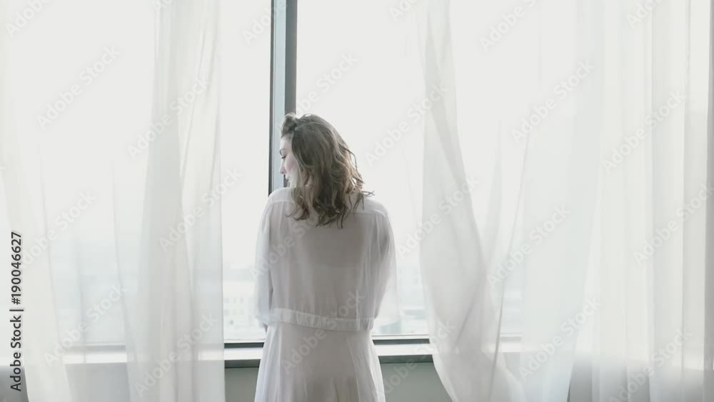 Silhouette of young girl dancer on windowsiil in dance studio indoors Silhouette of young girl dancer on windowsiil in dance studio indoors