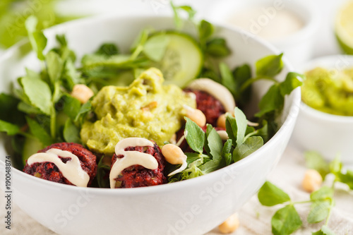 Green vegetable vegan salad with beets meatballs, Guacamole and tahini dressing. Healthy vegetarian food concept. Copy space