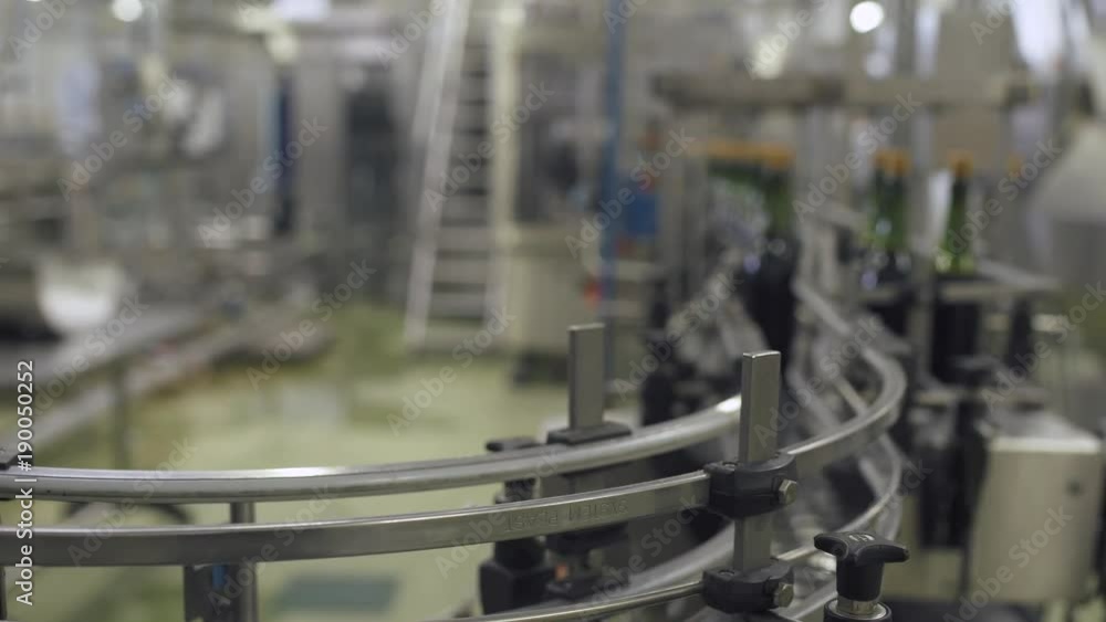 Factory of sparkling wines, view of bottles on the conveyor in motion, production of champagne.
Factory of sparkling wines, view of bottles on the conveyor in motion, production of champagne.