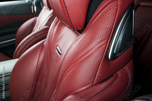 Modern Luxury car inside. Interior of prestige modern car. Comfortable leather red seats. Red perforated leather cockpit with isolated Black background. Modern car interior details