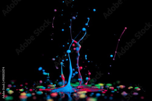 Splash of colorful liquid paint on a black background paint splash on black background © luchschenF