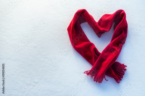 red scarf as heart on snow photo