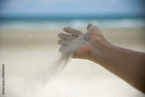  Release hand, Let it go and Freedom concept. Hand let go of woman release sand on beautiful sea beach and blue water background.