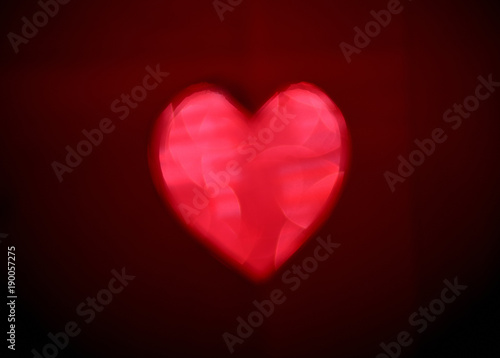 Big red Blur heart shape of ligth bokeh on a black background.