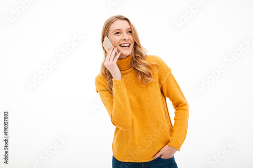Happy young lady talking by mobile phone.